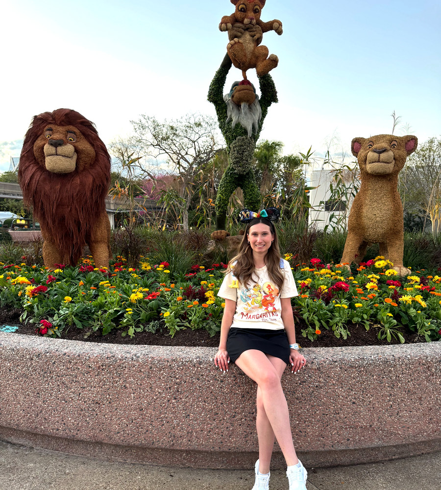 Maddie of Magic Moment Dreammakers at a Disney park flower garden